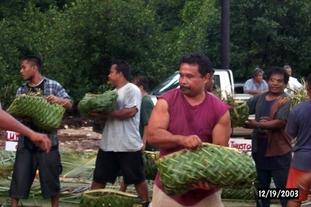 Rinson Phillip passes baskets of coconuts