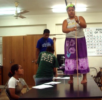 Ivyleen stands on the table while Yahne records data.