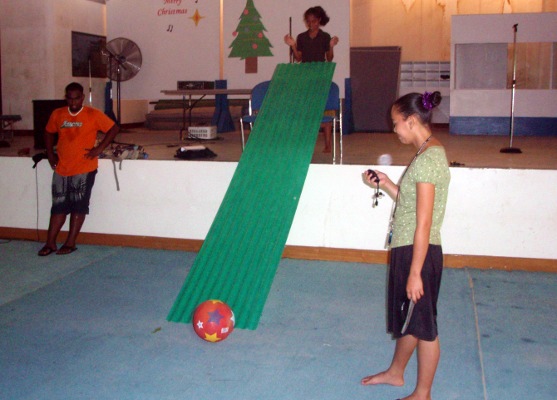 Jake, Breechlyn, and Elsieleen rolled a ball down a ramp in the practice gym.